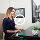 A video thumbnail image with a play button featuring the Goldtouch EasyLift Desk with a woman typing on her keyboard using the keyboard tray at the desk.